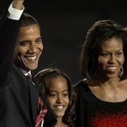 Barack Obama salue la foule en compagnie de sa fille aînée et de son épouse, Michelle Obama.