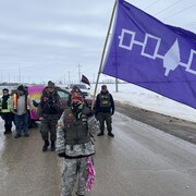 Des manifestants brandissant un drapeau. 