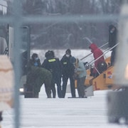 Les Canadiens évacués de Wuhan, en Chine, descendent de l'avion qui les a conduits à Trenton, en Ontario. 