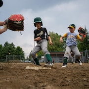 des enfants jouent au baseball.