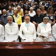 Des religieuses prient assises dans une église.