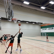 Des jeunes de l'école secondaire Saint-Jean-Eudes jouent au basketball.