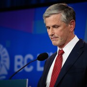 Andrew Wilkinson, la mine basse, s'adresse aux médias.