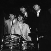 Les Beatles posent pour les journalistes près de la batterie de Ringo Starr.