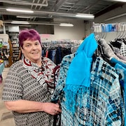 Betty Begg-Brooks devant un étalage de vêtements dans sa boutique.