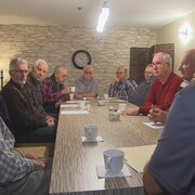 Des anciens employés de l'usine Belgo de Shawinigan réunis autour d'une table