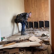Des bénévoles s'affairent à mitiger les dégâts dans le duplex d'Andrée-Anne Théroux à Baie-Saint-Paul.
