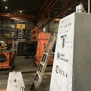 L'intérieur de l'usine. Un bloc de béton se trouve à l'avant-plan. 