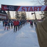Des gens massés à la ligne de départ d'une course de ski de fond. 11 février 2023