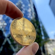 Une pièce de monnaie marquée du logo du Bitcoin.