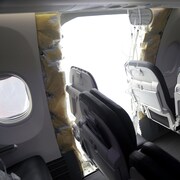Un trou de la grandeur d'une porte est visible à l'intérieur d'un avion.