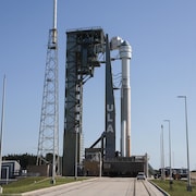 Le vaisseau Starliner au sommet d'une fusée Atlas V sur sa plateforme de lancement.
