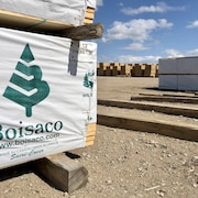 Le logo de Boisaco est apposé sur une pile de planches de bois d'oeuvre. 