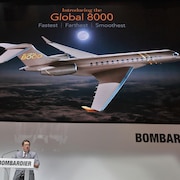 Éric Martel lors de sa présentation à Genève. Derrière lui, une immense affiche montre une maquette du Global 8000.