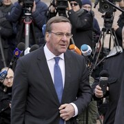 Le ministre allemand de la Défense Boris Pistorius, part après une conférence de presse, avec derrière lui de nombreux journalistes.