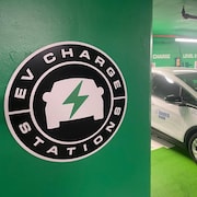 Un véhicule électrique est stationné sur une place réservée à la recharge électrique dans un stationnement souterrain.
