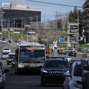 Un autobus circule dans la même voie que les autres véhicules sur un boulevard. 