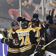 Des partisans des Boston Bruins réagissent avec enthousiasme à un but de Patrice Bergeron.