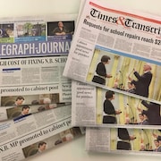 Six journaux de 2017 étalés sur une table : trois copies du Telegraph-Journal et trois du Times & Transcript.