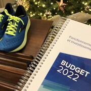 Le cahier du budget 2022, déposé à côté de la paire de souliers de course du maire.