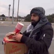 Un homme tient une boîte de café.