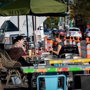 Deux femmes sont attablées à une terrasse.