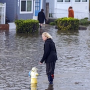 Dawn Wilkinson, résidente d'Aptos Beach Flats, traverse les eaux de crue depuis sa maison à Aptos, en Californie.
