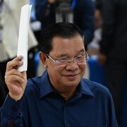 Hun Sen tient son bulletin de vote dans sa main droite.