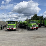 Des camions de recyclage de l'asphalte garés.