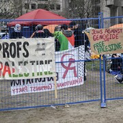 Des banderoles accrochées sur des barrières sur lesquelles on peut lire : Profs Palestine, Jews Against Genocide Say Palestine, ou You are funding genocide.