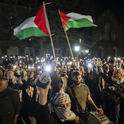 Des manifestants tiennent des drapeaux palestiniens.