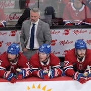 Quatre joueurs du Canadien sont assis sur leur banc.