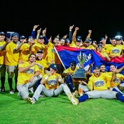 Les Capitales sont champions de la Ligue Frontière pour une deuxième année de suite. Les joueurs posent pour une photo de groupe avec le trophée.