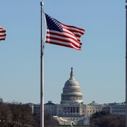 Le Capitole derrière des drapeaux américains. 