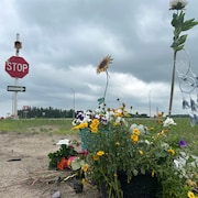 Des fleurs et objets forment un mémorial près d'une intersection d'autoroute.