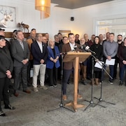 Des gens rassemblés derrière le préfet de la Haute-Gaspésie.