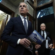 Le premier ministre Mark Carney, à gauche, et le ministre des Finances et du Revenu national, François-Philippe Champagne, se rendent à la Chambre des communes pour présenter la mise à jour économique du printemps sur la colline du Parlement, à Ottawa, le mardi 28 avril 2026.