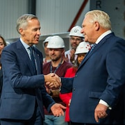 Le premier ministre canadien Mark Carney serre la main à Doug Ford.