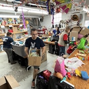 Des personnes ramassent des jouets.