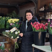La floricultrice Catherine Brassard a un bouquet de tulipes dans les mains. 