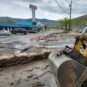 Des équipements lourds s'affairent à nettoyer les rues de Cache Creek, en Colombie-Britannique, à la suite des inondations, le samedi 6 mai 2023.
