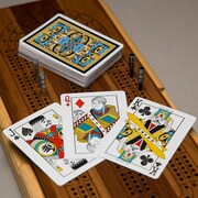 Trois cartes à jouer et une pile de cartes sont déposées sur une planche de cribbage.