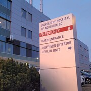 Un panneau indique la direction de l'urgence et de l'entrée principale de l'Hôpital universitaire du Nord de la Colombie-Britannique, à Prince George.