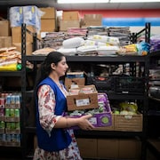 Une bénévole transporte des denrées à la banque alimentaire Guru Nanak de Surrey, en banlieue de Vancouver, le 19 avril 2024.