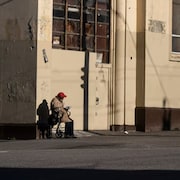 Une personne assise seule au coin d'une rue du quartier Downtown Eastside, à Vancouver, sur une photo non datée.