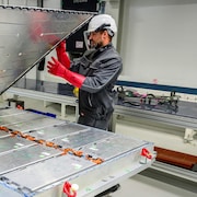 Deux employés travaillent sur un module de batteries.