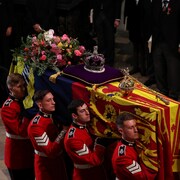 Le cercueil de la reine Élisabeth II est soulevé par des porteurs.