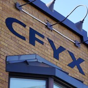 L'enseigne de la station CFYX sur un immeuble de briques à Rimouski.                               