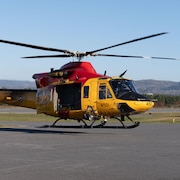 L'hélicoptère de recherche et sauvetage en train d'atterrir sur le tarmac de l'aéroport de Sainte-Anne-des-Monts.