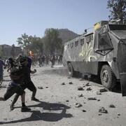 Des manifestants lancent des pierres sur un canon à eau de la police à Santiago.